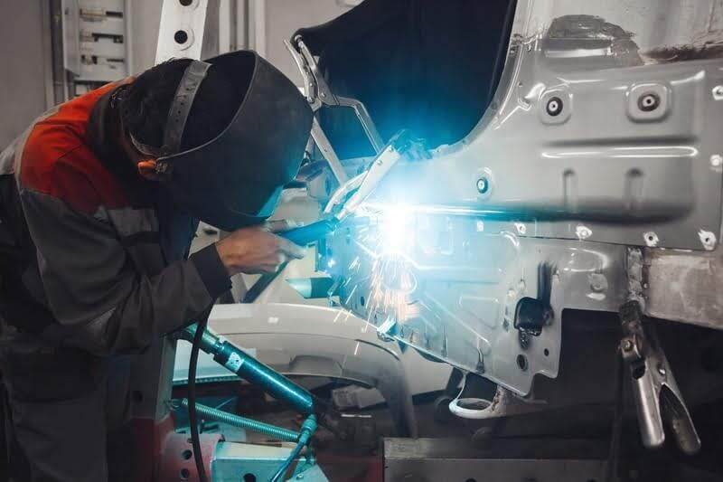 man welding a car door